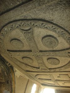 Rock cut church ceiling with carved stone Greek cross and circles